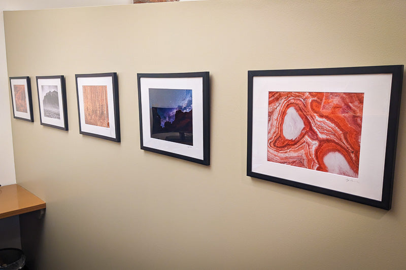 Framed prints by Anthony Roderman hanging in an office.